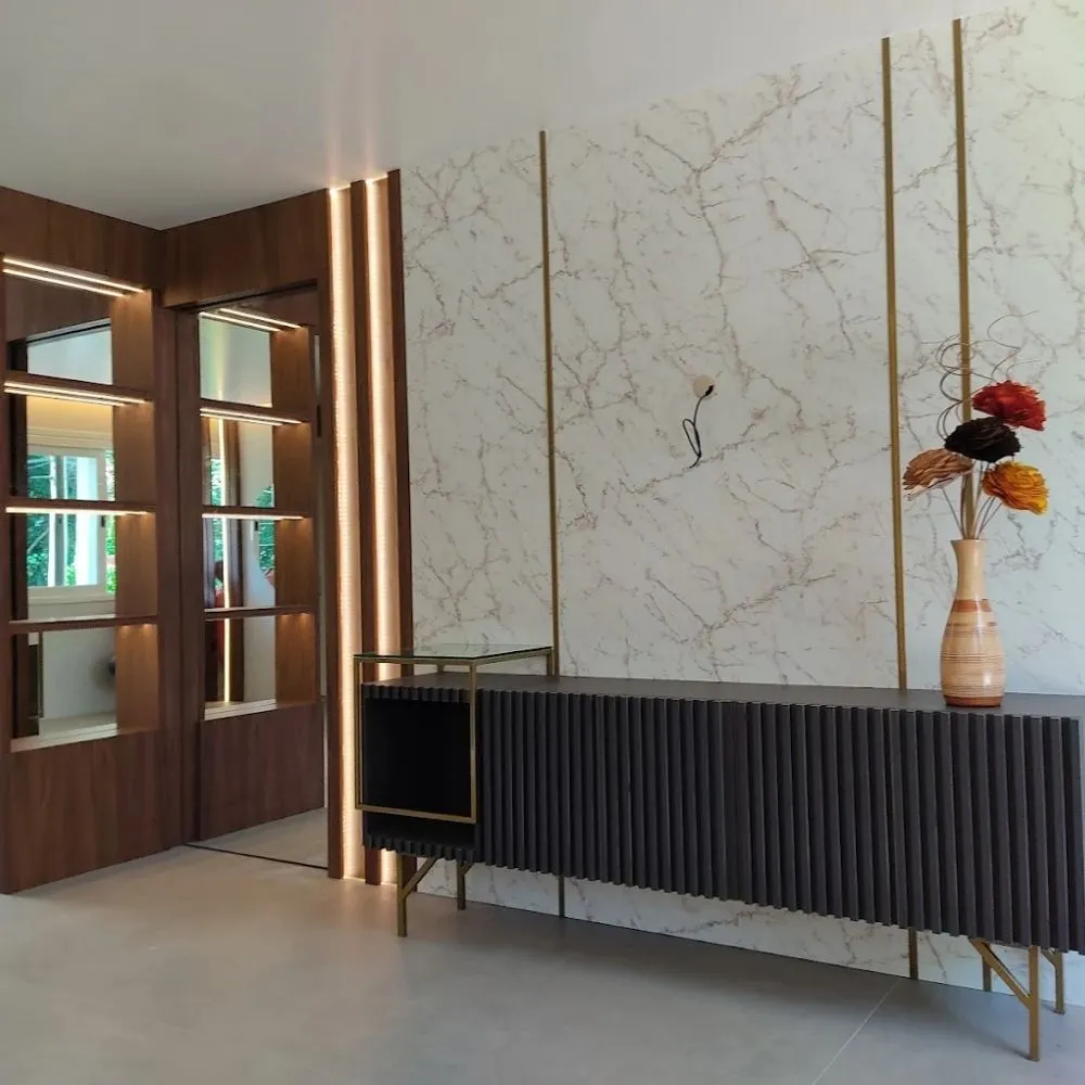 Hall de entrada com painel ripado, mármore e detalhes em dourado