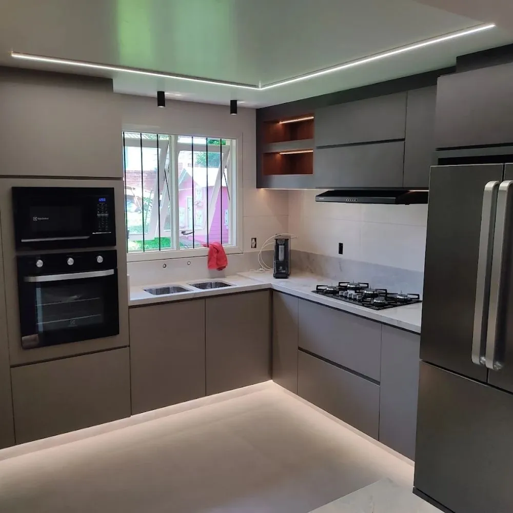 Cozinha em formato L com iluminação embutida e eletrodomésticos integrados